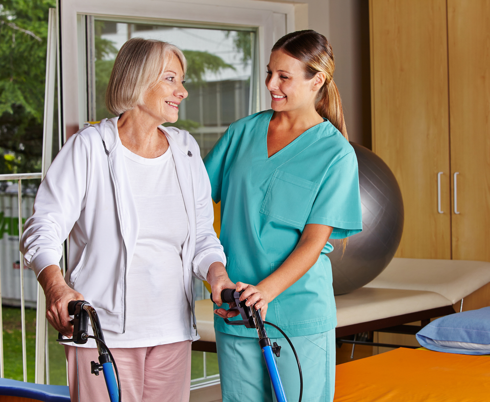 physical therapist helping a female resident