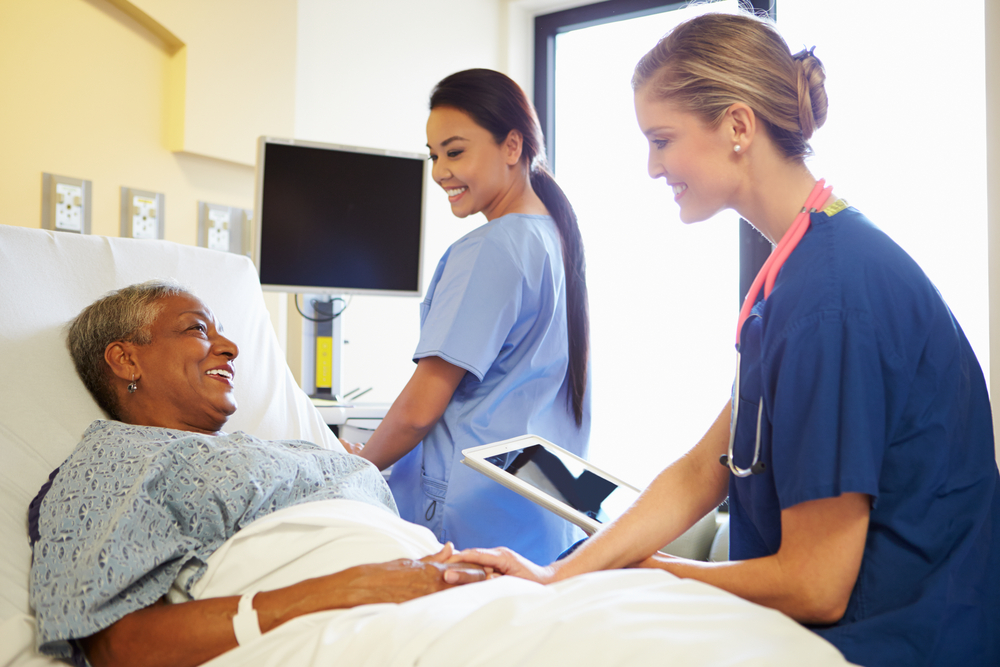 nurses checking on patient in bed