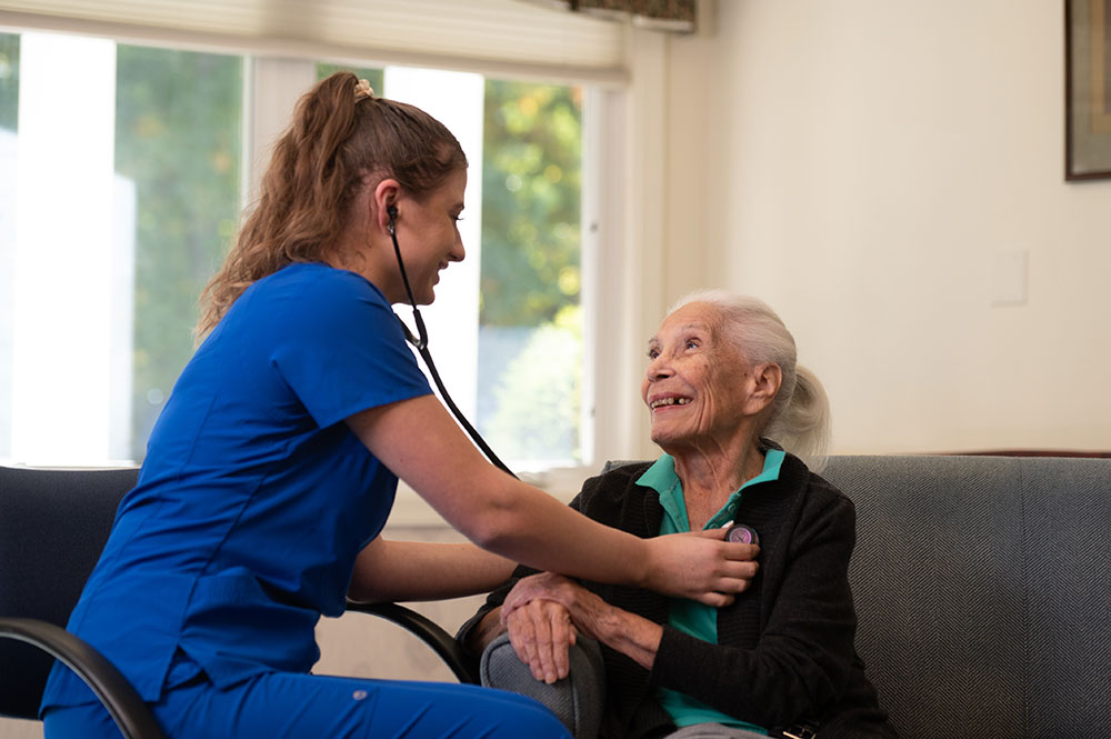 Caregiver checking female residents heartbeat