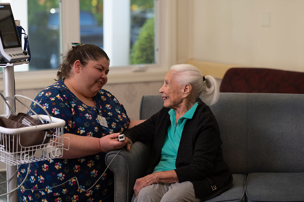 care giver checking on a female resident