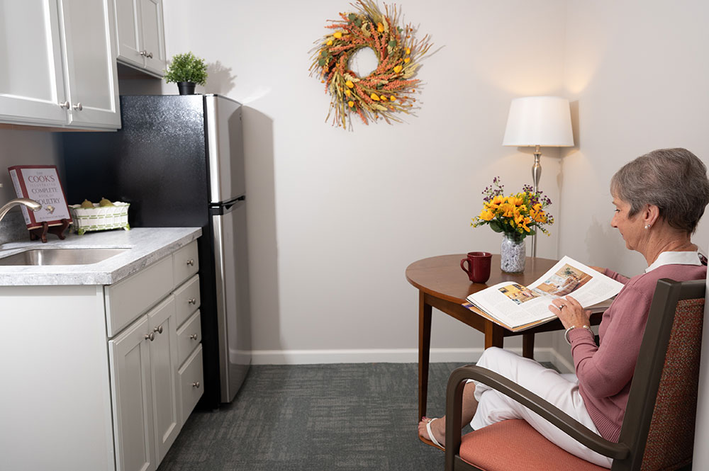 woman sitting at memory care kitchenette