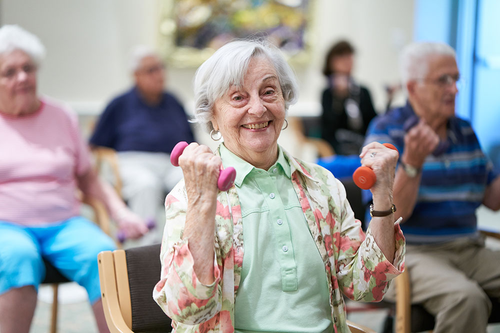 female resident lifting small hand weights