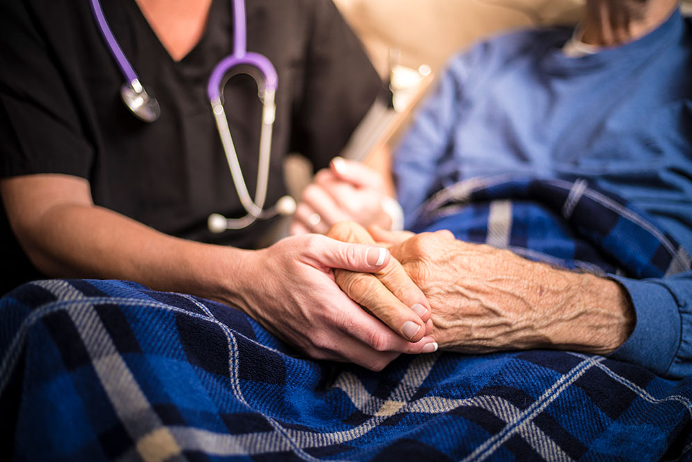 care giver holding patient's hand