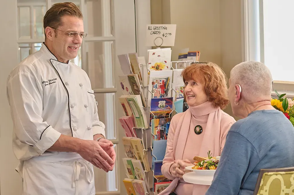 two woman talking with the chef