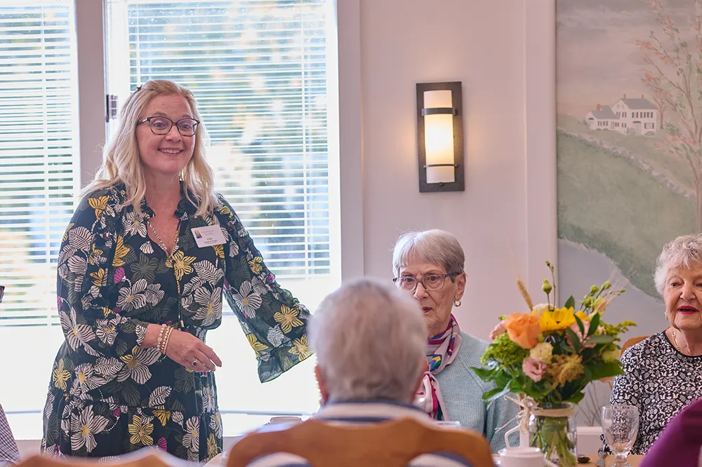 a team member speaking with people at a table