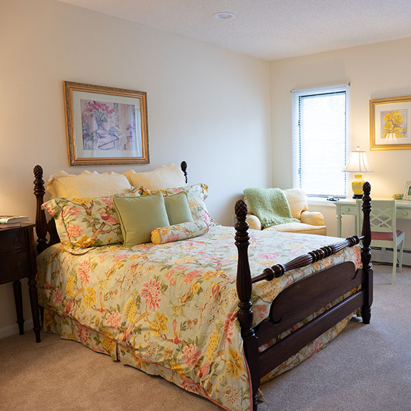 Bright interior living room of a Putnam apartment at Pomperaug Woods showing a seating area with sofa or chairs and a large window letting in natural light.