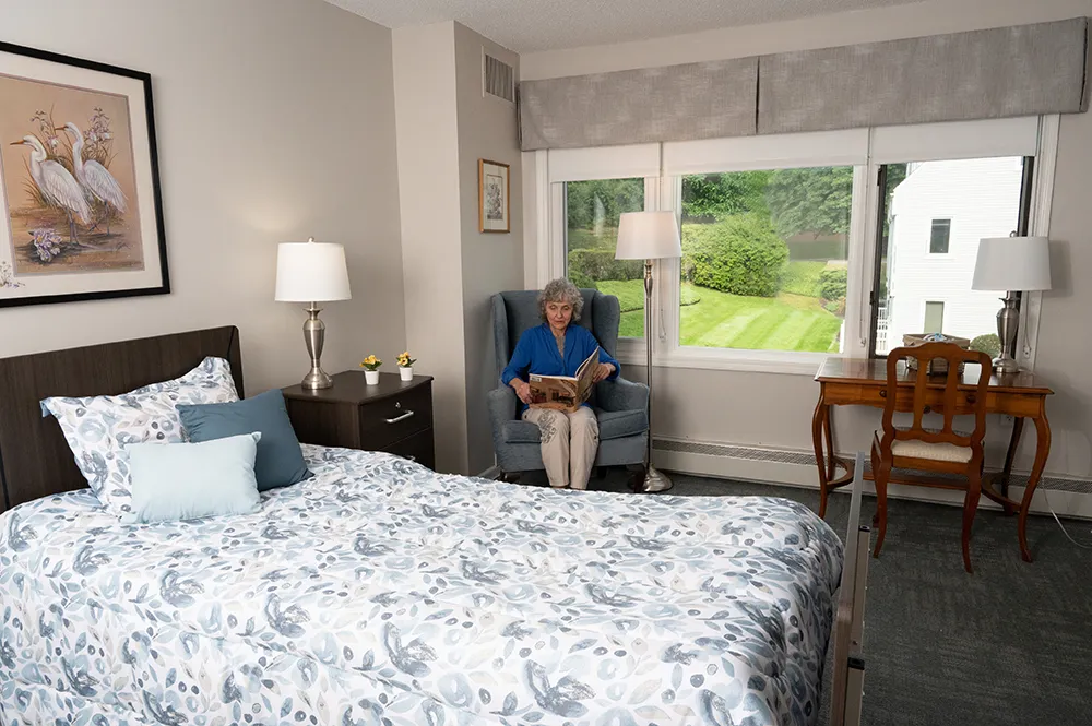 a female resident sitting in her room reading a book
