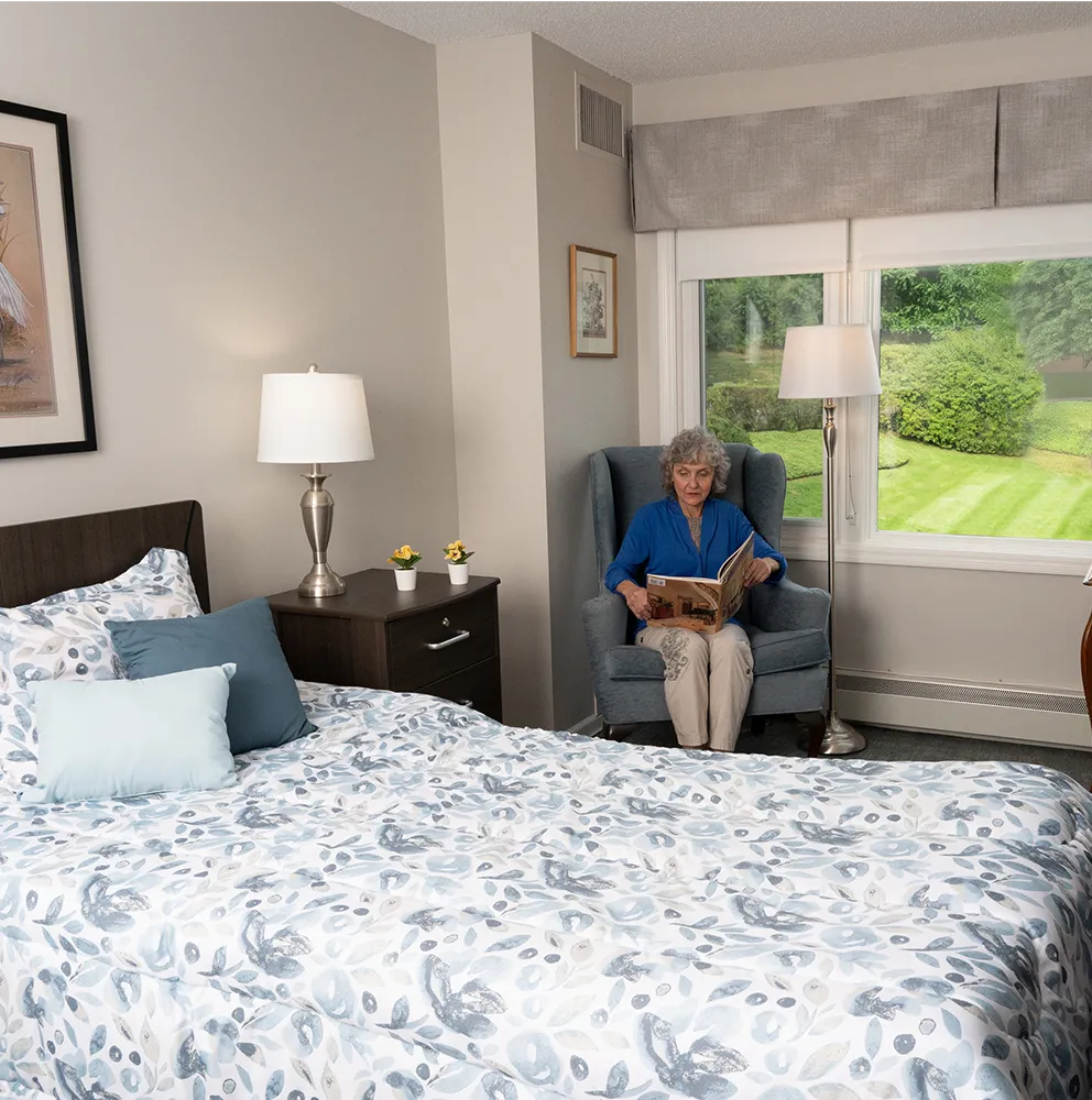 a female resident sitting in her room reading a book